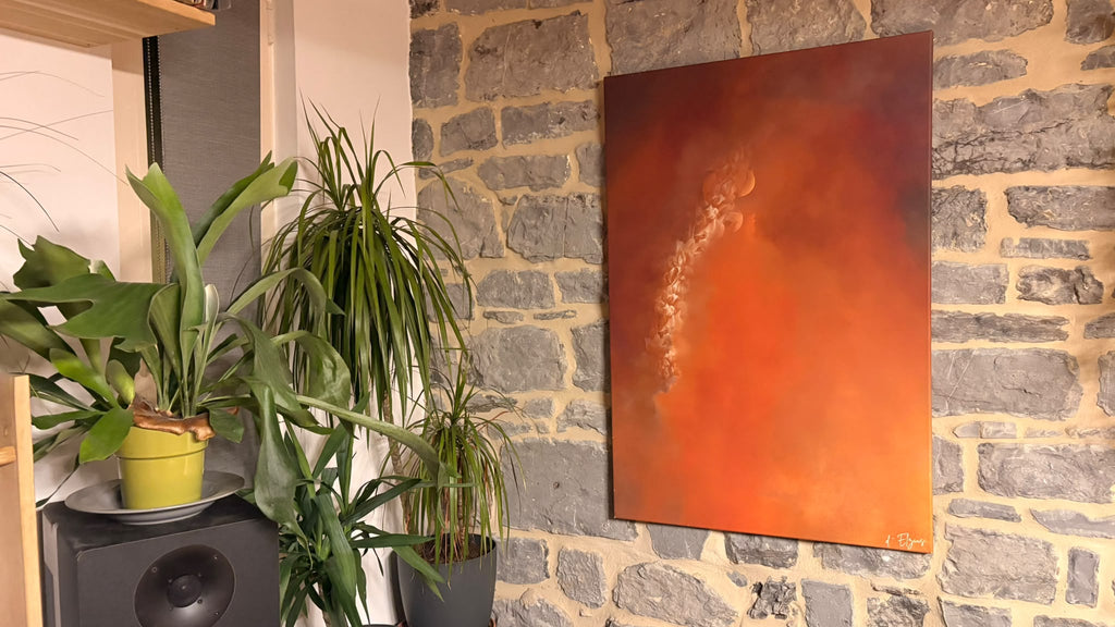 Le drame cathare accroché sur un mur de briques, à côté d’une plante verte.