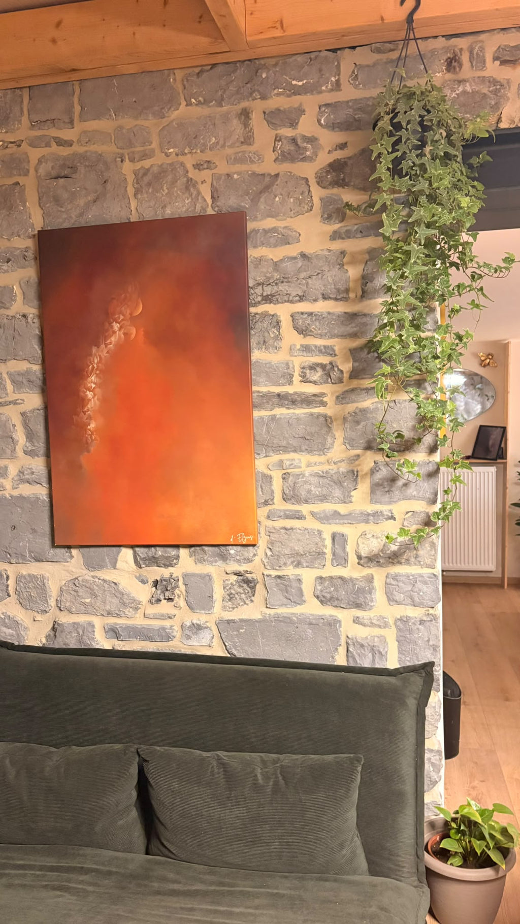 Le drame cathare accroché au-dessus d’une tête de lit, entre un mur de briques et une plante grimpante.
